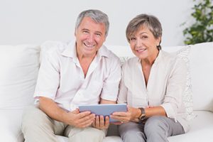 old couple looking camera with tablet pc in their hands